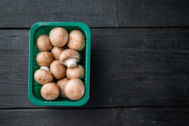 Kraliyet şampiyonları, Paris şampiyonları seti, siyah ahşap masa arkaplanında, plastik pakette, üst görünüm düz yerde, metin kopyasına yer var.