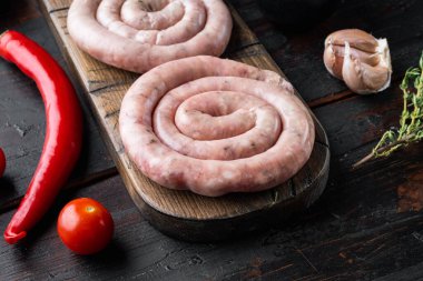 Saf spiral sosis seti, eski, siyah ahşap masa arkasında.