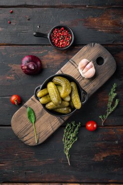 Fermente edilmiş sebze turşusu salatalık seti, eski koyu ahşap masa arkaplanı, üst manzara düz yatıyordu