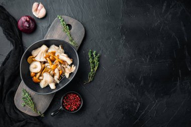 Yağ kümesinde konserve mantarlar, siyah arkaplan, üst görünüm düz, metin kopyalama alanı için boşluk