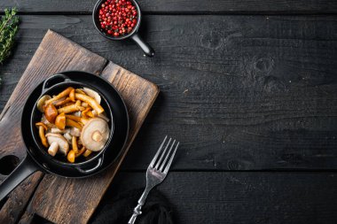 Terbiye edilmiş mantarlar seti, siyah ahşap masa arkaplanı, üst görünüm düz yatay, metin kopyalama alanı için boşluk