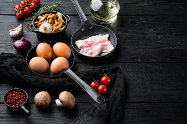 Kızarmış yumurtalar için sağlıklı kahvaltı malzemeleri, siyah ahşap masa zemininde, metin kopyalama alanı için yer var.