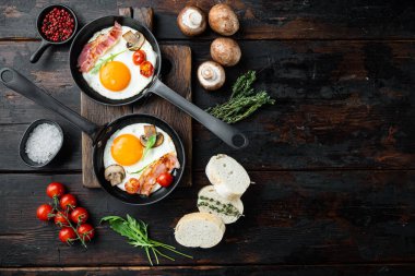 Kızarmış yumurta ve kiraz domatesli ve kahvaltıda demir tavada ekmek, eski koyu ahşap masa zemininde, üst düz yerde, metin kopyalanacak yeri var.