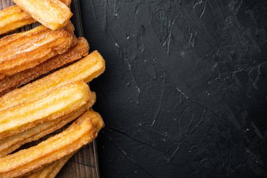 Çikolatalı Churros, geleneksel İspanyol dişi, siyah arkaplan, üst görünüm düz metin, kopyalanma alanı
