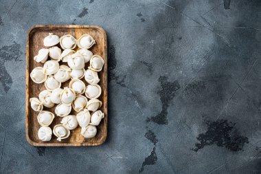 Tortellini ve Ravioli donmuş hamur köfteleri ahşap kutuda, gri arka planda, üst görünüm düz yerde, metin için metin alanı ve boşluğu ile birlikte.