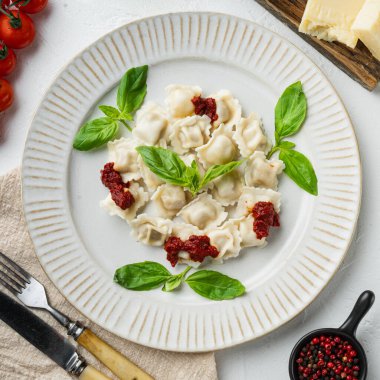 Mantar soslu ve peynirli Ravioli makarnası. Fesleğenli ve domatesli İtalyan yemeği. Beyaz tabakta.