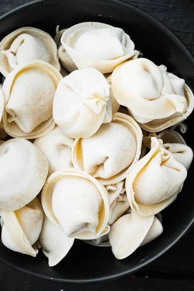 Frozen Dumplings Tortellini Ravioli Set Black Bowl Black Wooden Table — Stock Photo, Image