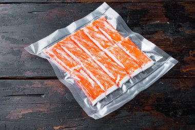 Yengeç çubuğu surimi vakum seti, koyu ahşap arka plan