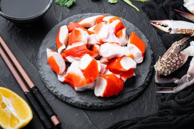 Taze Yengeç eti Surimi mavi yüzme yengeci takımlı, taş tahtada, siyah arka planda