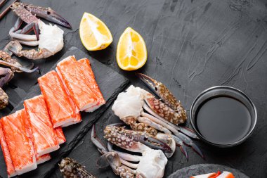 Yengeç çubukları, yarı pişmiş balık kıyması, mavi yüzme yengeci seti, siyah arkaplan, üst görünüm düz, metin için telif alanı ve boşluk