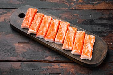 Yengeç köfteleri, deniz ürünleri, balık kıyması, mavi yüzme yengeci seti, ahşap kesim tahtası, koyu ahşap arka plan.