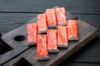 Yengeç köfteleri, deniz ürünleri, balık kıyması, mavi yüzme yengeci seti, tahta kesme tahtası, siyah ahşap masa arkaplanı.