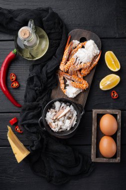 Kırmızı biberli yengeç ipeksi omlet malzemeleri seti, siyah ahşap masa arkaplanı, üst görünüm düz