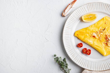Yengeç etli ve peynirli kızarmış omlet, tabakta, beyaz arka planda, üst manzara düz, metin için yer ve metin alanı var.