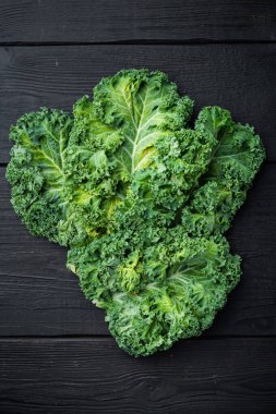 Taze yeşil lahana yaprağı. Beslenme seti kralı, siyah ahşap masa arkaplanı üzerinde, üst görünüm düz yatıyordu