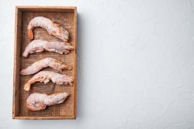 Donmuş Arjantin kırmızı karidesleri, kafaları ayarlı, tahta kutuda, beyaz arka planda, üst manzara düz, kopyalanmış alan ve metin için boşluk