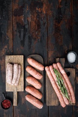 Domuz eti, sığır eti ve tavuk sosisi seti. Eski, siyah ahşap arka planda, yazı için yeri olan düz bir yer..