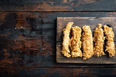 Eski siyah ahşap masa üzerinde kızarmış tavuk budu kesikleri, üst manzara, fotokopi alanı ile..