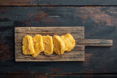 Kızarmış tavuk nugget eti. Eski, siyah ahşap masada, üst tarafta..