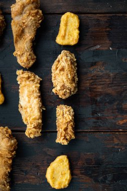 Koyu ahşap arka planda kızarmış tavuk kesikleri, düz yayılmış, metin için yeri var..