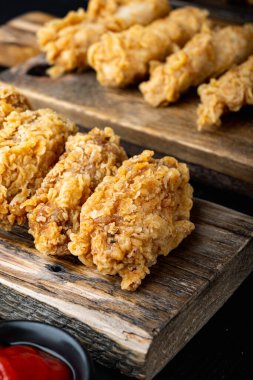 Siyah ahşap masada Kore usulü kızarmış tavuk pirzolası..