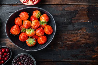 Olgun kırmızı çilek, koyu ahşap zemin üzerinde üst görünüm, kopyalama alanı ile.