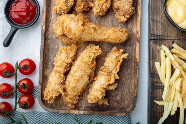 Хрустящие жареные куриные порезы на белом фоне, вид сверху.