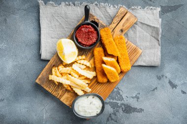 Beyaz sarımsak soslu altın balık kroket yığını, ahşap kesim tahtası, gri arka plan, üst görünüm düz, kopyalanacak yer ve metin için boşluk
