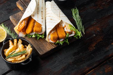 Balık kroket seti ve tartar sosu seti, ahşap kesim tahtası üzerinde, eski koyu tahta masa zemininde, metin alanı ve boşluğu ile