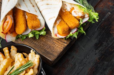 Balıklı sandviç rulosu, peynir ve sebze seti, ahşap kesim tahtası, eski koyu ahşap masa arka planı, kopyalanacak yer ve metin için yer