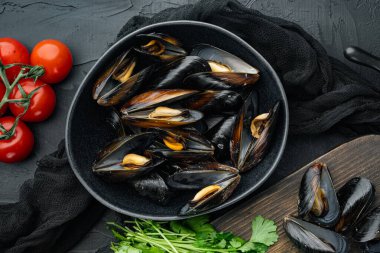 Limon ve baget soslu çiğ midyeler, kâse içinde, siyah arka planda, üst manzara düz.