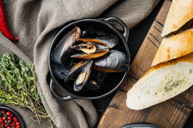 Klasik buharda pişirilmiş midye kabuklu beyaz şarap, siyah ahşap masa arkaplanı, üst manzara düz.