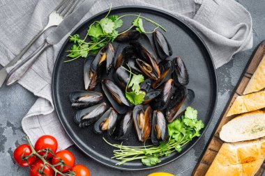 Çiğ midyeler limon ve baget seti, tabakta, gri arka planda, üst manzara düz