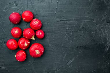 Sebze yığını kırmızı turp kümesi, siyah arkaplan, üst görünüm düz, metin için telif alanı ve boşluk