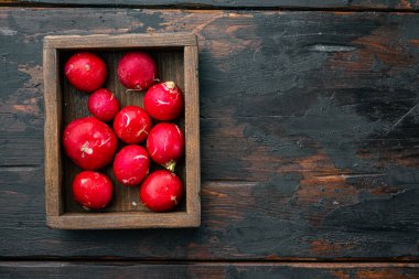 Yaz, kırmızı turp hasat etti. Büyüyen organik sebzeler, ahşap kutuda, eski koyu ahşap masa zemininde, üst görünüm düz yerde, metin için metin alanı ve boşluğu ile