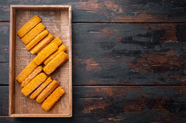 Donmuş balık ekmek kırıntıları, ahşap kutuda, eski koyu ahşap masa zemininde, telif alanı ve metin alanı ile üst görünüm düz yatıyordu