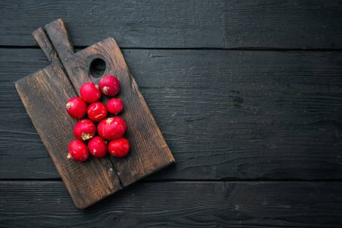 Sebze yığını kırmızı turplar seti, ahşap kesim tahtası, siyah ahşap masa arkaplanı, üst görünüm düz, kopyalanacak yer ve metin için alan
