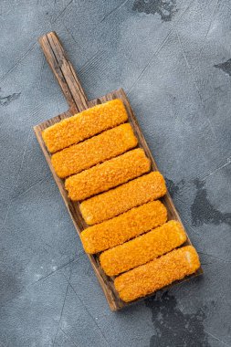 Donmuş balık kırıntıları seti, ahşap kesim tahtasına, gri arka plana, üst manzara düz yatıyordu.