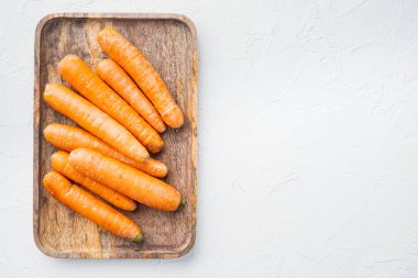 Güzel olgun havuç arkaplan seti, ahşap tepside, beyaz zemin üzerinde, telif alanı ve metin alanı ile üst görünüm düz yatar