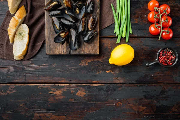 Çiğ midyeler limon ve baget seti, ahşap kesim tahtası, eski koyu ahşap masa arkaplanı, üst görünüm düz, metin alanı ve boşluğu ile