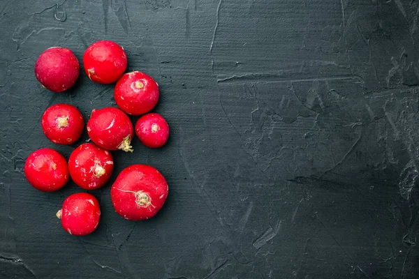 Sebze yığını kırmızı turp kümesi, siyah arkaplan, üst görünüm düz, metin için telif alanı ve boşluk