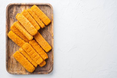 Donmuş balık parmakları ayarlandı, ahşap tepside, beyaz zemin üzerinde, telif alanı ve metin için yeri olan üst görünüm düzlüğü