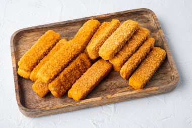 Tahta tepside, beyaz arkaplanda çıtır balık kroket.