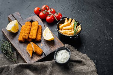 Balık kroket ve patates kızartması, tartar soslu İngiliz fast food seti, ahşap kesim tahtası, siyah arka plan, metin için kopyalanacak yer ve yer.