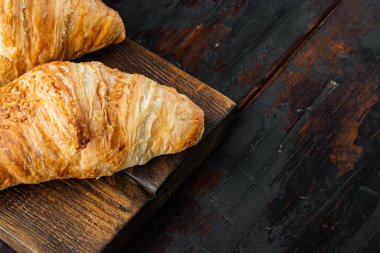 Fransız kruvasan seti, eski koyu ahşap masa arkaplanı, üst görünüm düz, metin için kopyalama alanı ile