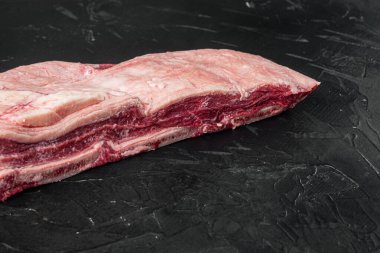 Çiğ sığır eti kısa kaburga seti, siyah taş zemin üzerinde, metin için kopyalama alanı ile