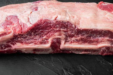 Siyah taştan arka planda çiğ pirzola kalbi seti.