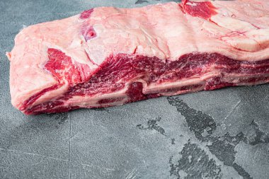 Çiğ Siyah Angus Mermer Sığır Pirzolası seti, gri taş zemin üzerinde, metin için kopyalama alanı ile