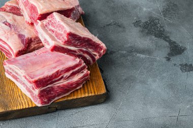 Çiğ sığır eti kısa kaburga seti, gri taş zemin üzerinde, metin için kopyalama alanı ile