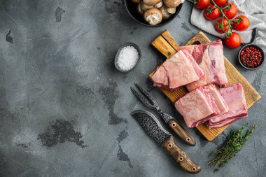 Çiğ sığır eti kısa kaburga seti, malzeme ile, gri taş zemin üzerinde, üst görünüm düz, metin için kopyalama alanı ile
